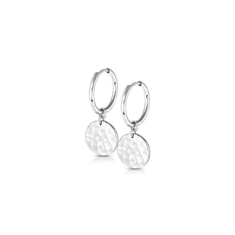 Silver tone hoop earrings with hammered round disc charms, polished huggie style drop earrings on white background
