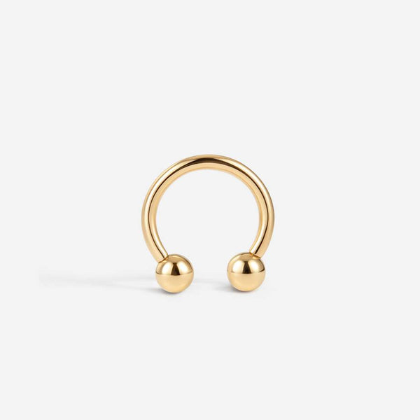 14K solid gold horseshoe piercing, shown with a curved open band and ball ends