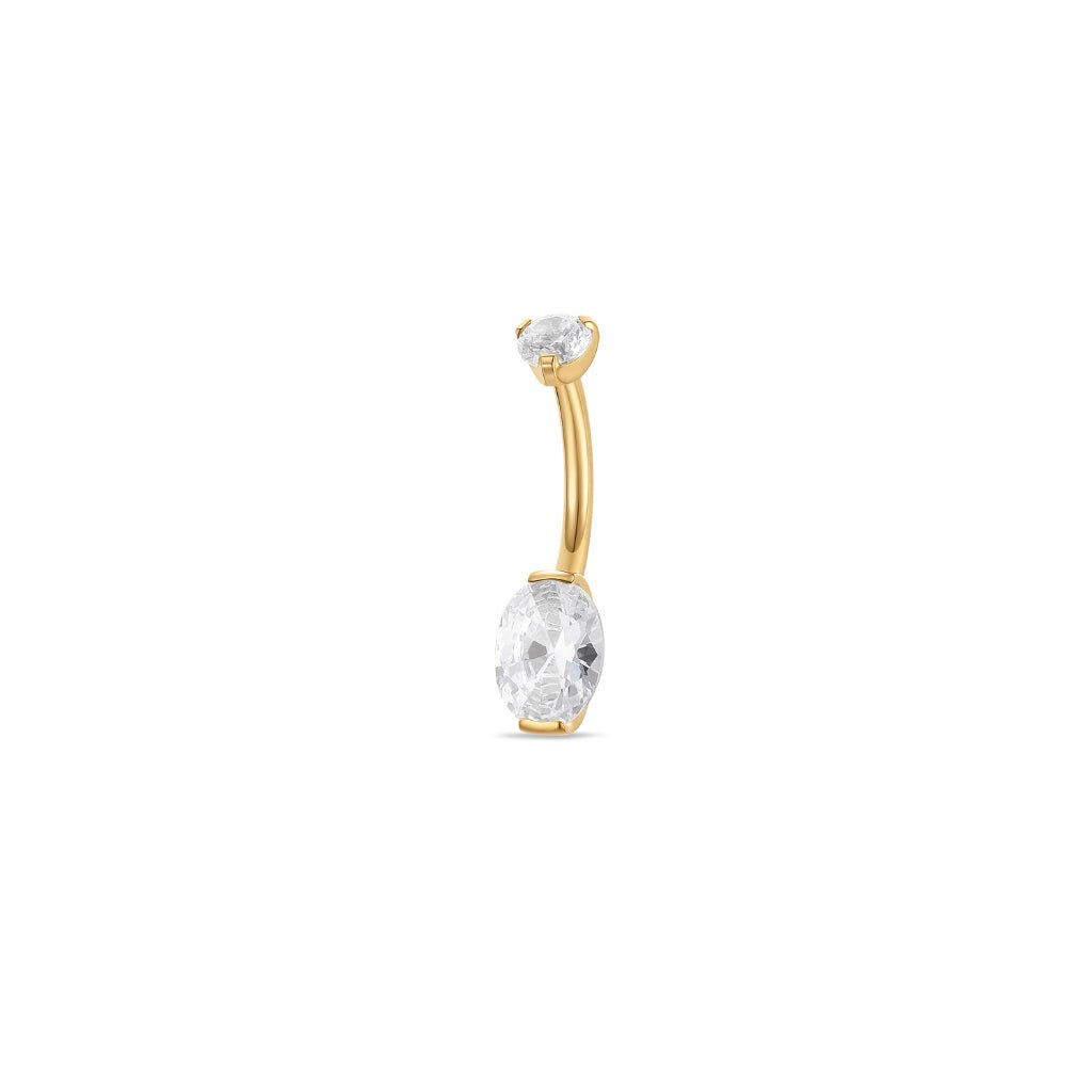 Gold-tone titanium navel bar with oval clear cubic zirconia in a half-bezel arc setting, shown on a white background.