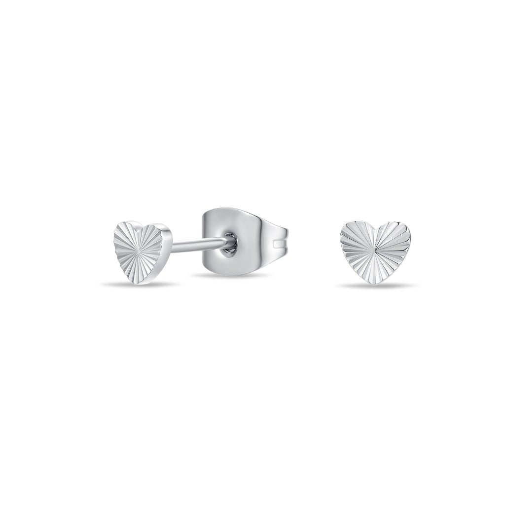 Close-up of surgical steel radiant heart stud earrings in silver tone, shown front-on and side-on to highlight the engraved heart texture and flat-back post design.