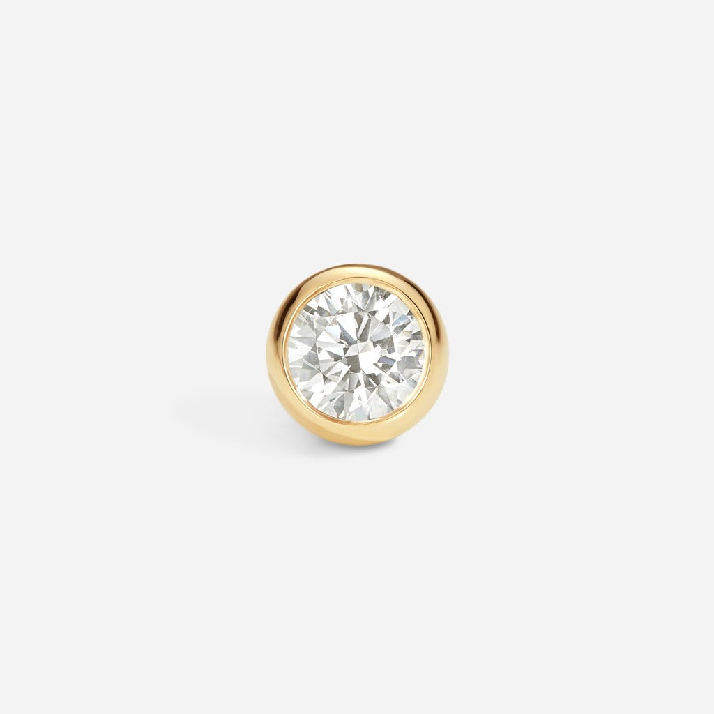 Gold bezel-set flatback stud featuring a round clear cubic zirconia stone in a classic minimalist piercing design.