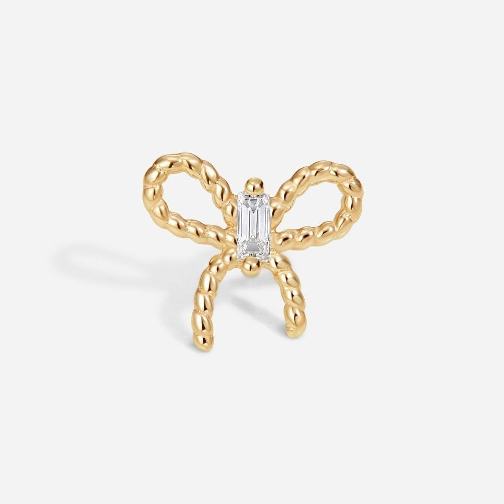 Gold bow flatback stud featuring a baguette-cut clear cubic zirconia centre stone and textured ribbon-inspired design.