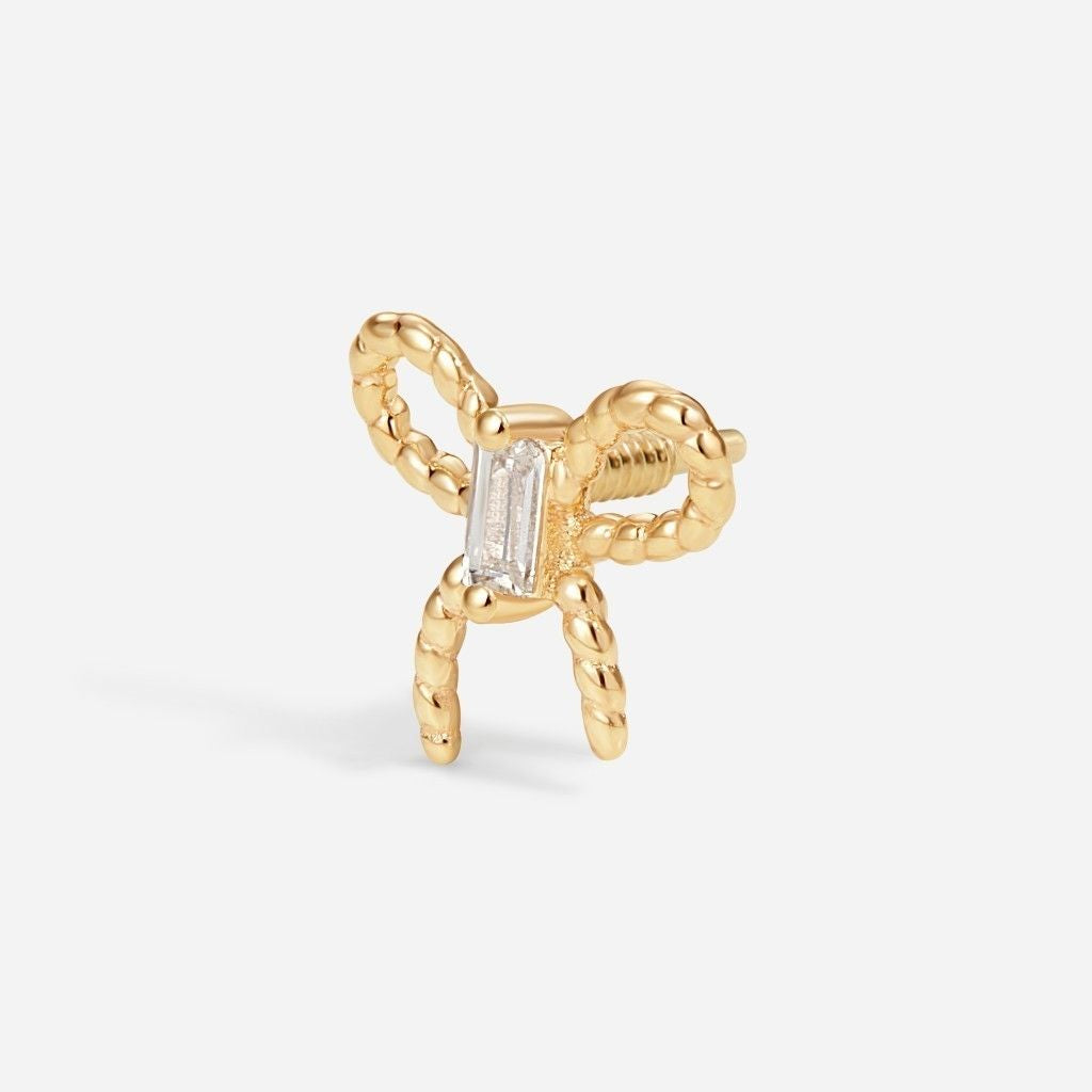 Gold bow flatback stud featuring a baguette-cut clear cubic zirconia centre stone and textured rope-style bow design viewed from an angled side profile.