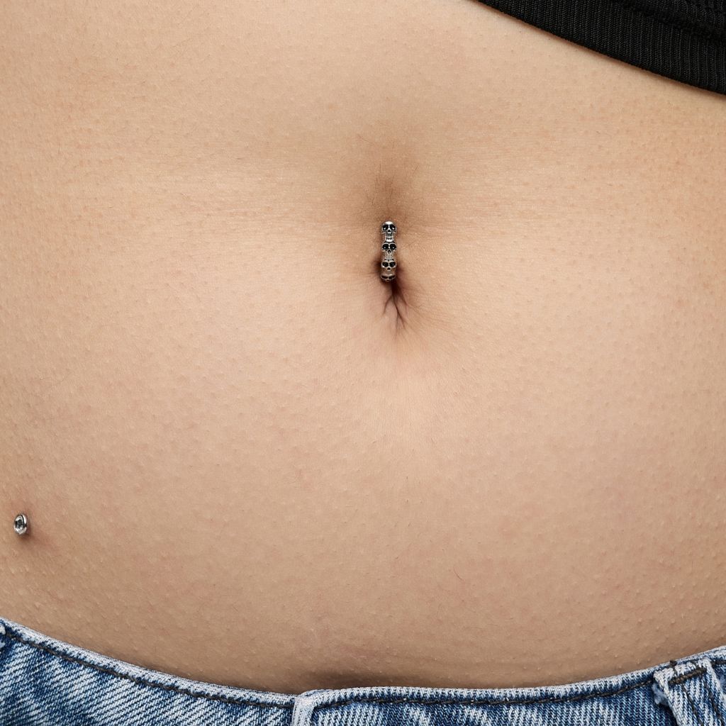 Skull navel clicker piercing with black cubic zirconia stone accents