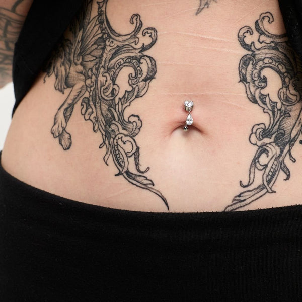 Titanium navel bar piercing with two dangling cubic zirconia stones