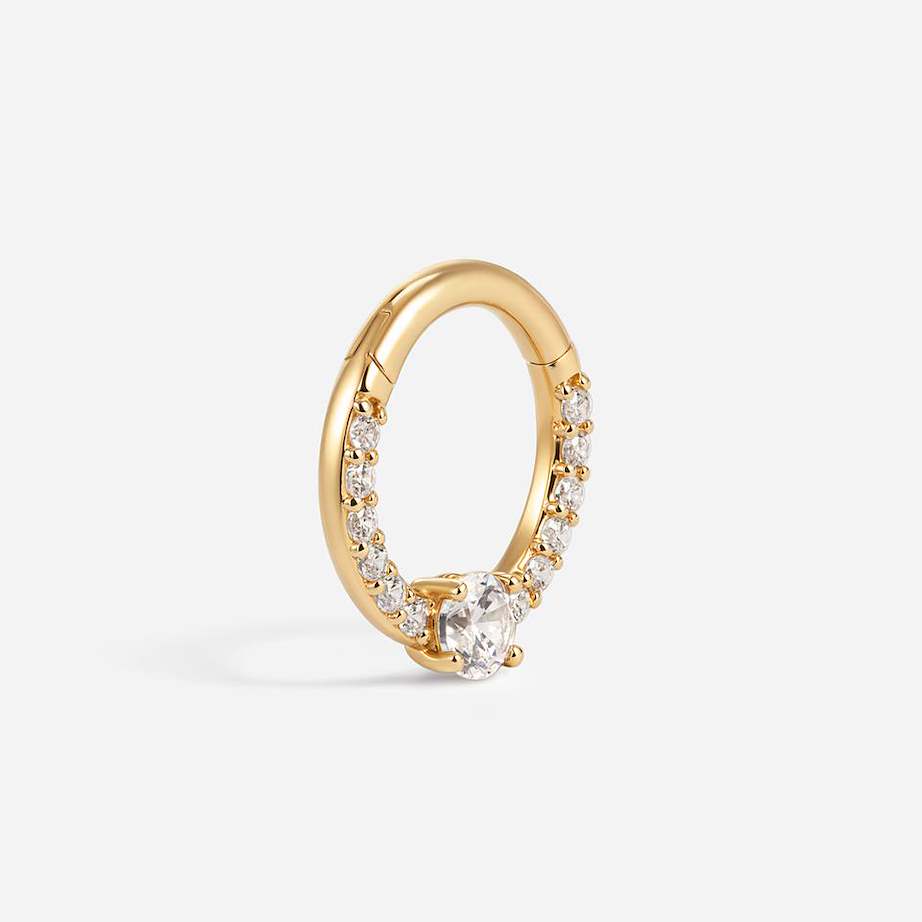 Gold segment ring shown at an angle, with a round clear CZ and stones set along the lower band